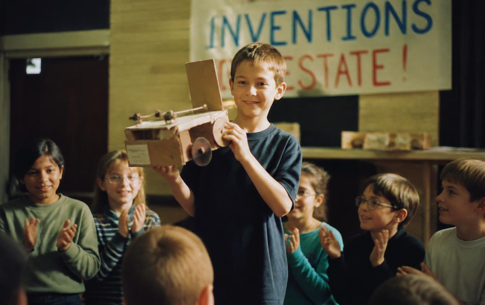 A child fixing a small appliance at a workbench with tools laid out
